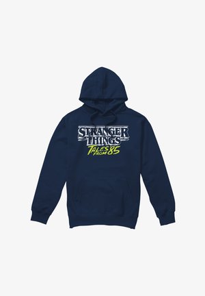 Navy blue hoodie with front pocket showing "Stranger Things Tales from 85" logo in white and bright yellow text.