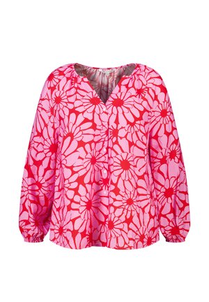 Blouse boutonnée à manches longues, avec un motif floral de grandes marguerites rose vif et rouge, et des poignets élastiqués froncés.