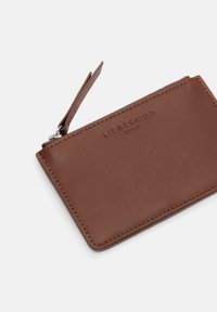 Brązowy skórzany etui na karty o teksturowanym wykończeniu, z zamkiem błyskawicznym i małym paskiem. Z przodu tłoczone logo. Kompaktowy design.