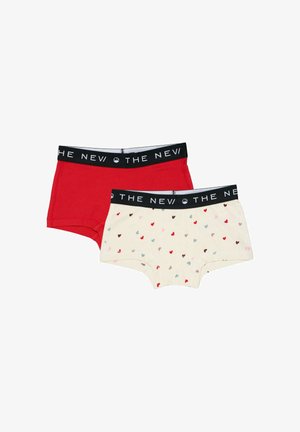 Deux paires de boxers pour enfants, l'un rouge uni et l'autre crème avec de petits cœurs multicolores, tous deux avec des bandes élastiques noires à la taille.