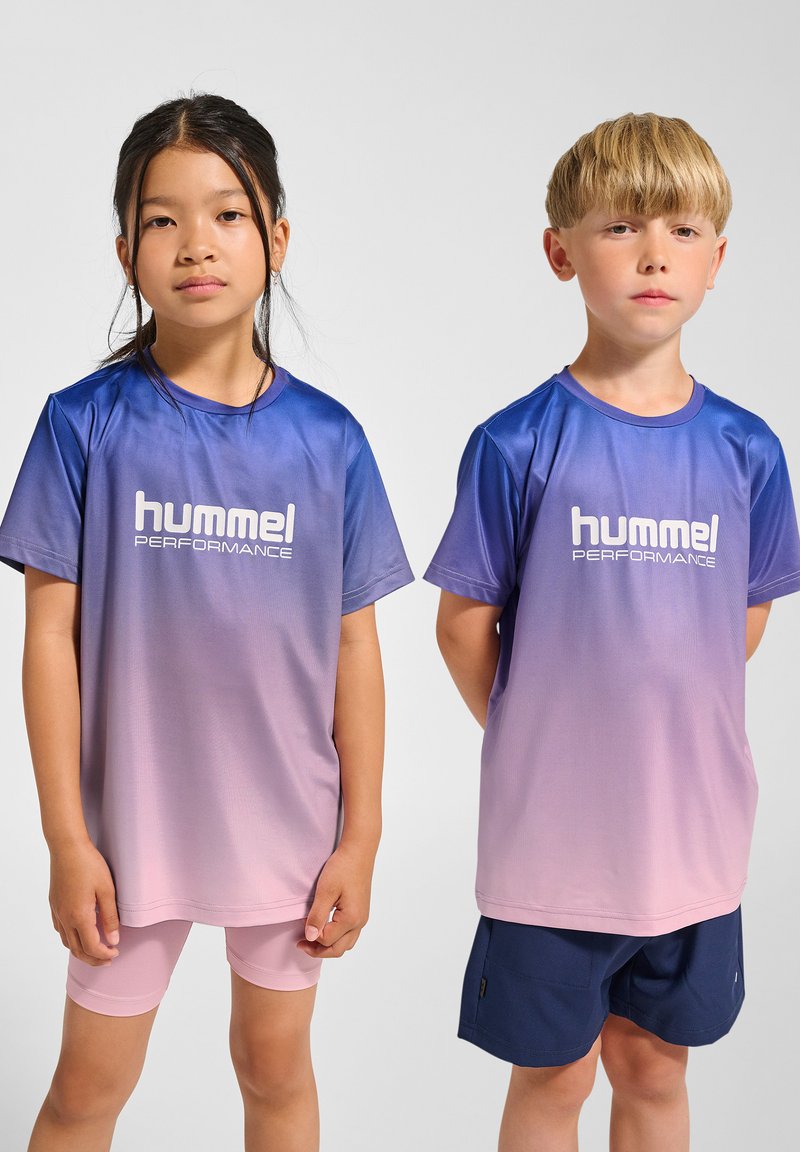 Två barn bär Hummel Performance-kläder: en gradvis blå till rosa t-shirt och rosa shorts för flickan, och marinblå shorts för pojken.