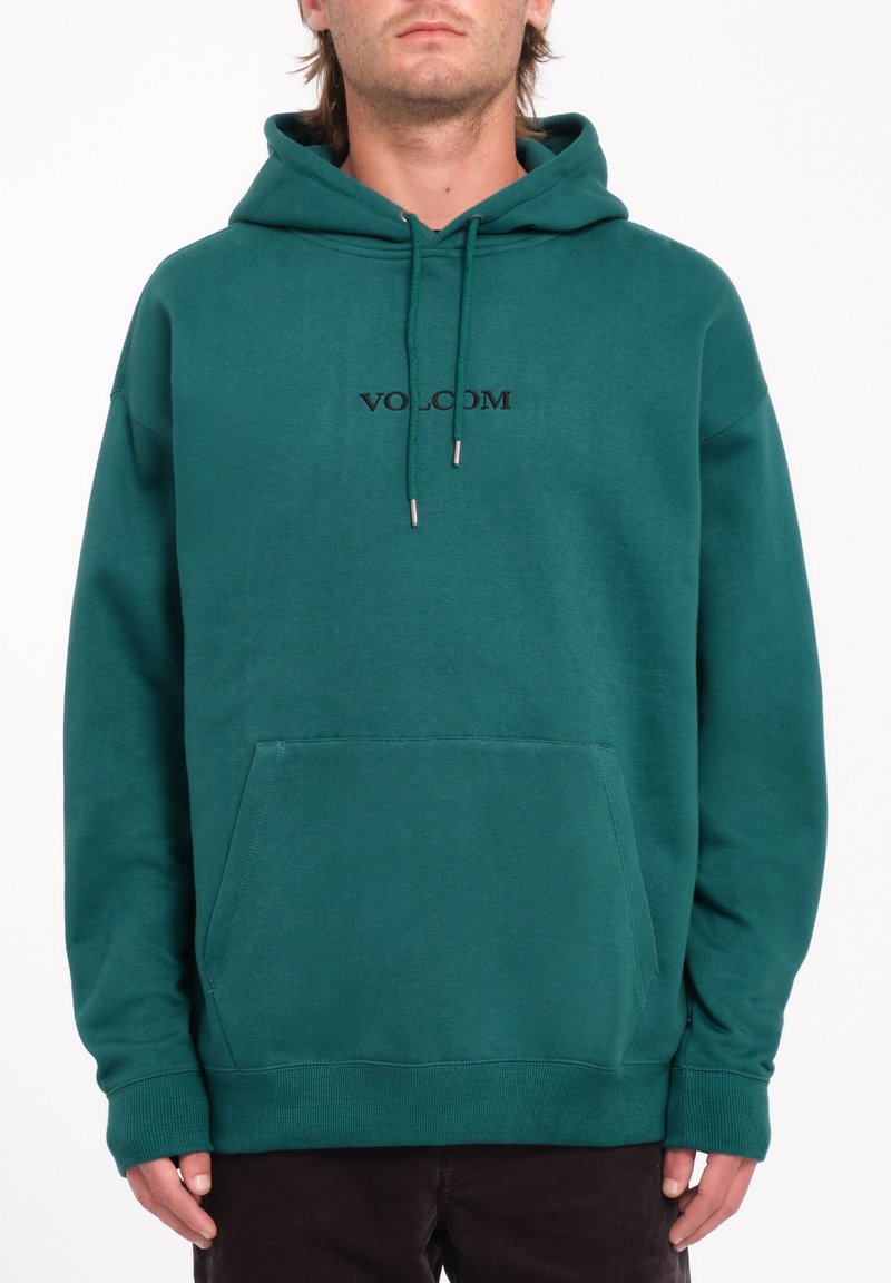 Sweat à capuche vert foncé avec poche kangourou, cordon de serrage à la capuche et logo "VOLCOM" brodé sur la poitrine. Matière en coton doux.