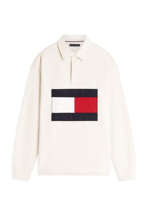 Langermet poloskjorte i kremfarge med et marineblått og rødt logoemblem som viser "TOMMY HILFIGER." Har krage og ribbestrikkede mansjetter.