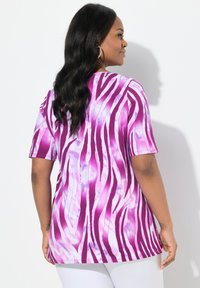 Camiseta de manga corta a rayas de cebra en púrpura y rosa con un ajuste relajado, que presenta un cuello redondo y una tela suave y ligera.