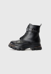 Black leather ankle boot with a rounded toe, lace-up front, buckle detail, and chunky rubber sole. Features a small loop at the back.