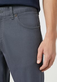 Grijze jeans met een gladde textuur, voorzien van een vijf-pocket ontwerp, contrasterende stiksel en metalen hardware accenten.