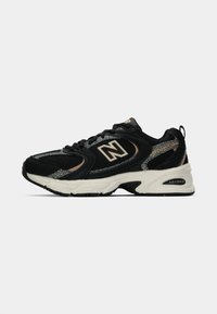 Sneaker New Balance 530 em preto e bege com parte superior em malha e camurça, sola branca acolchoada e tecnologia de amortecimento ABZORB.