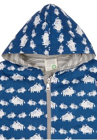 Blå zip-up hoodie med ett upprepat mönster av vita djur, mjukt bomullsmaterial, grå randig inre fodring och en påtagligt fodrad huva.