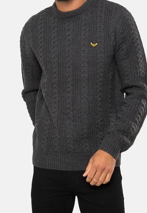 Dark gray knitted sweater with a textured cable design. Features a round neckline and a small yellow logo on the chest.