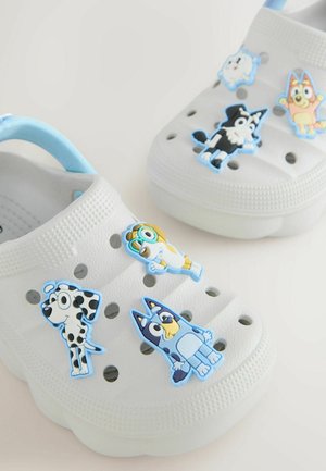 Weißer Clog mit blauen Akzenten und Cartoon-Figuren als Verzierung. Material wirkt wie Kunststoff mit Belüftungslöchern und strukturierter Oberfläche.