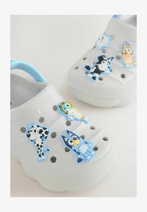 Sabot blanc avec accents bleus, décoré de personnages de dessins animés. Le matériau semble être du plastique avec des trous de ventilation et une surface texturée.