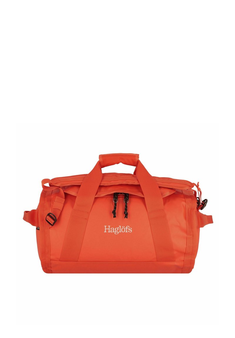 Bolsa de lona naranja brillante con dos asas, cierre de cremallera y el logo de "Haglöfs" en el panel frontal central.