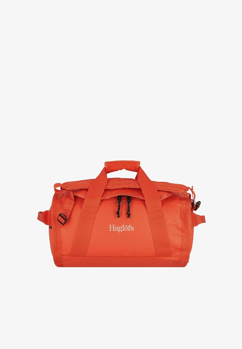 Borsa da viaggio arancione brillante con doppie maniglie, chiusura a zip e il logo "Haglöfs" sul pannello centrale anteriore.