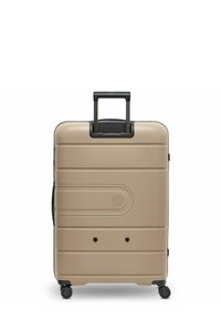 Beige harde koffer met vier wielen, een verlengde zwarte telescopische handgreep en textuur met horizontale lijnen op het oppervlak.