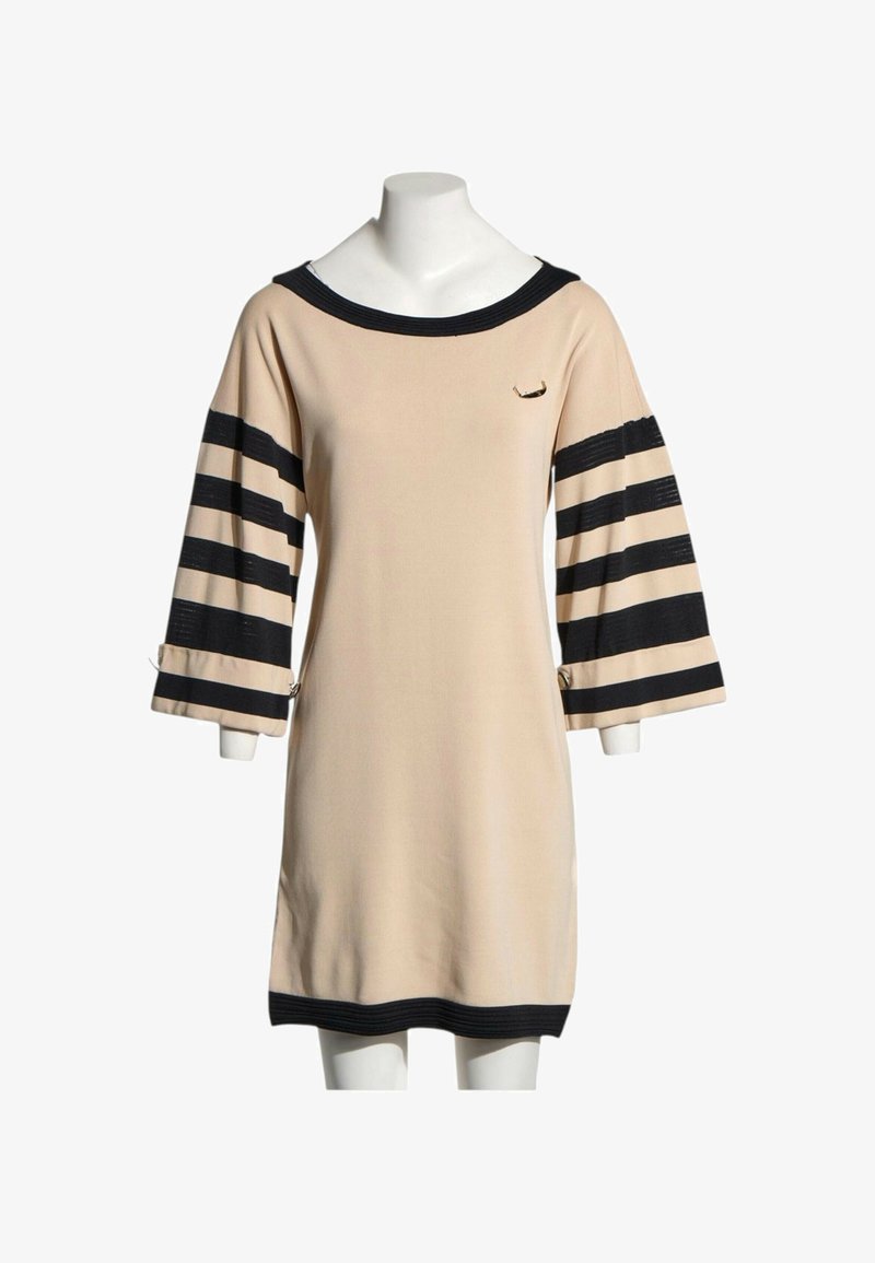 Robe beige avec un large col noir, des rayures noires aux manches trois-quarts et une bande noire à l'ourlet sur mannequin.