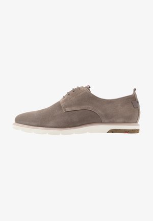 Zapato de vestir casual para hombre en color topo con textura, cordones, suela blanca y pequeña lengüeta en el talón.