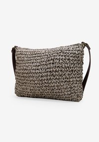 Borsa a tracolla intrecciata marrone con superficie testurizzata, forma rettangolare e tracolla marrone. Presenta un colore neutro con una finitura naturale e rustica.