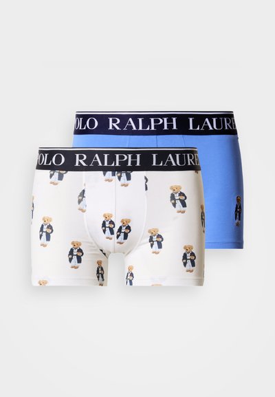 To par Polo Ralph Lauren boxer briefs, ett ensfarget blått og ett hvitt med et motiv av en teddybjørn, begge med svarte merkelogoer på midjebåndet.