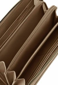 Cartera de cuero marrón con superficie texturizada, cierre de cremallera, múltiples compartimentos y slots para tarjetas. Se pueden ver detalles de acento en el cierre de cremallera en tono dorado.