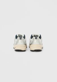 Běžecké boty s stříbrným síťovaným svrškem s námořnickými doplňky, polstrovanou béžovou podrážkou a zadními poutky pro snadné nazouvání.