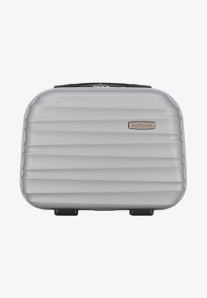 Cofanetto cosmetico rigido argento con design a coste testurizzato, zip nera e targa in metallo. Include quattro piedini in gomma nera per stabilità.