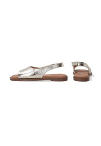 Metaliske guld slingback sandaler med åben tå, flad brun sål og glat overflade. Har en slank rem for sikker pasform.