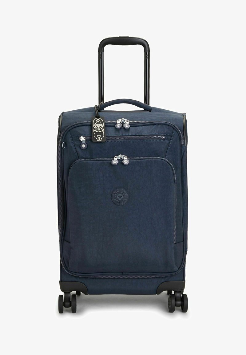 Marineblauer Hartschalenkoffer mit ausziehbarem Griff, vier Rädern, vorderem Reißverschlussfach und einem dekorativen Gepäckanhänger. Strukturierte Oberfläche und Logo.