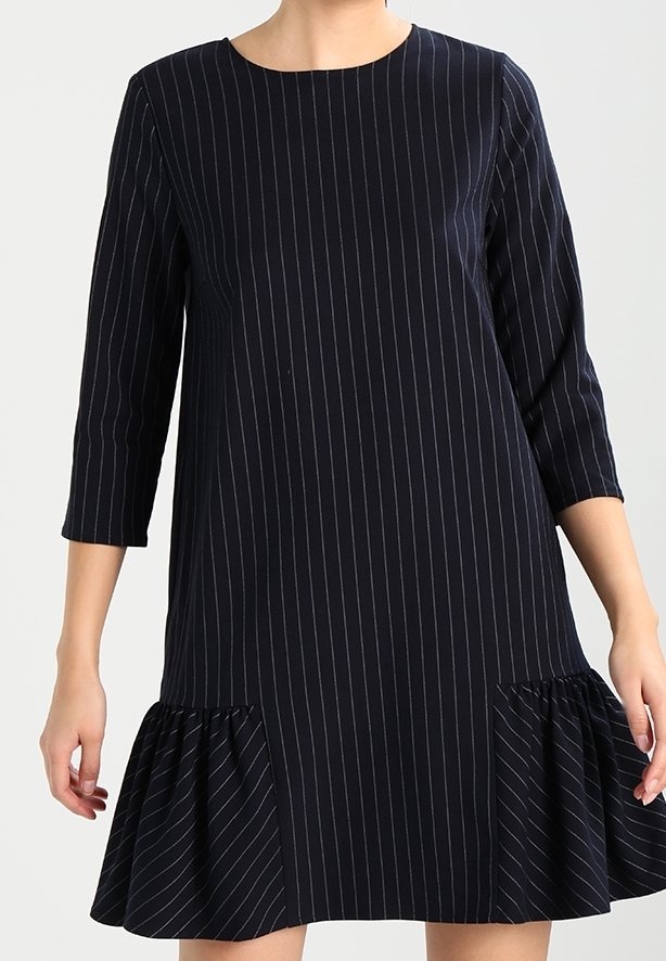 Marineblaues Kleid mit horizontalen weißen Streifen, runder Ausschnitt, Dreiviertelärmel und rüschengesäumtem Saum am unteren Ende.