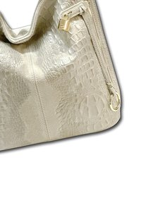Beige handtas van textuurleer met een krokodillenpatroon. Voorzien van een gouden ritssluiting en een decoratieve slotaccent.