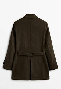 Cappotto in lana marrone con vestibilità su misura, ampi risvolti, due bottoni in vita e una spacco sul retro. Maniche lunghe con dettagli a bottoni.