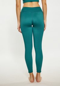 Teal leggings met een hoge taille, gemaakt van een gladde, rekbare stof. Heeft een aansluitend ontwerp en geen zichtbare patronen of hardware.