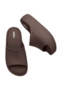 Sandali marroni senza lacci realizzati in materiale morbido, con un design a punta aperta, texture liscia e tacco curvo per un look contemporaneo.