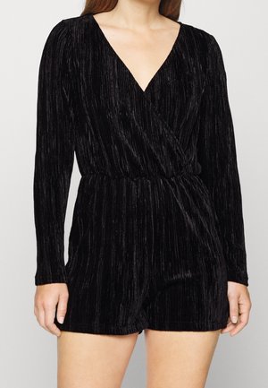 Czarny welurowy kombinezon z długimi rękawami i głębokim dekoltem w kształcie V, z marszczoną talią i pionowym prążkowanym wzorem, charakteryzujący się dopasowanym i strukturalnym wyglądem.
