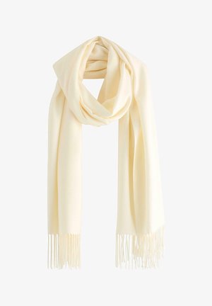 Kremowy szalik wykonany z miękkiego materiału, charakteryzujący się gładką teksturą i długimi frędzlami po obu końcach. Ułożony w pętlę.