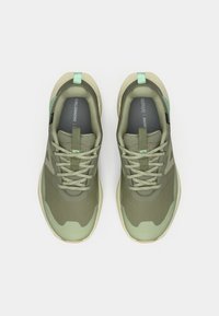 Πράσινα αθλητικά παπούτσια με πλέγμα στο πάνω μέρος, στρογγυλεμένη μύτη και υφασμένο πέλμα. Κορδόνια και λεπτομέρειες σε πιο ανοιχτό πράσινο. Εμφανές ορθολίτης πάτος.