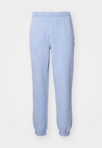 Pantalones de chándal azul claro hechos de una suave tela cepillada. Cuentan con una cinturilla elástica y puños elásticos en los tobillos. Diseño simple y aerodinámico.