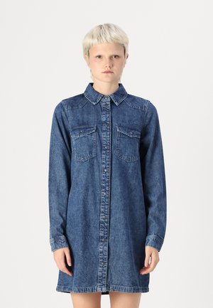 Denim shirtjurk met een knoopsluiting aan de voorkant, een spitse kraag, lange mouwen en twee borstzakken. In een middelblauwe wassing met een klassieke pasvorm.