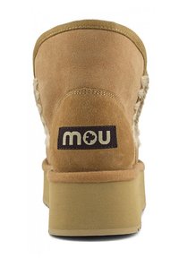 Stivale alla caviglia in suede di colore marrone chiaro, caratterizzato da un fusto testurizzato, dettagli cuciti e una suola con leggero plateau. Etichetta del marchio visibile.