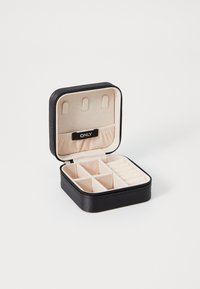 Black jewelry box with a zip closure, featuring a beige interior, multiple compartments, and a small black tag labeled "ONLY."