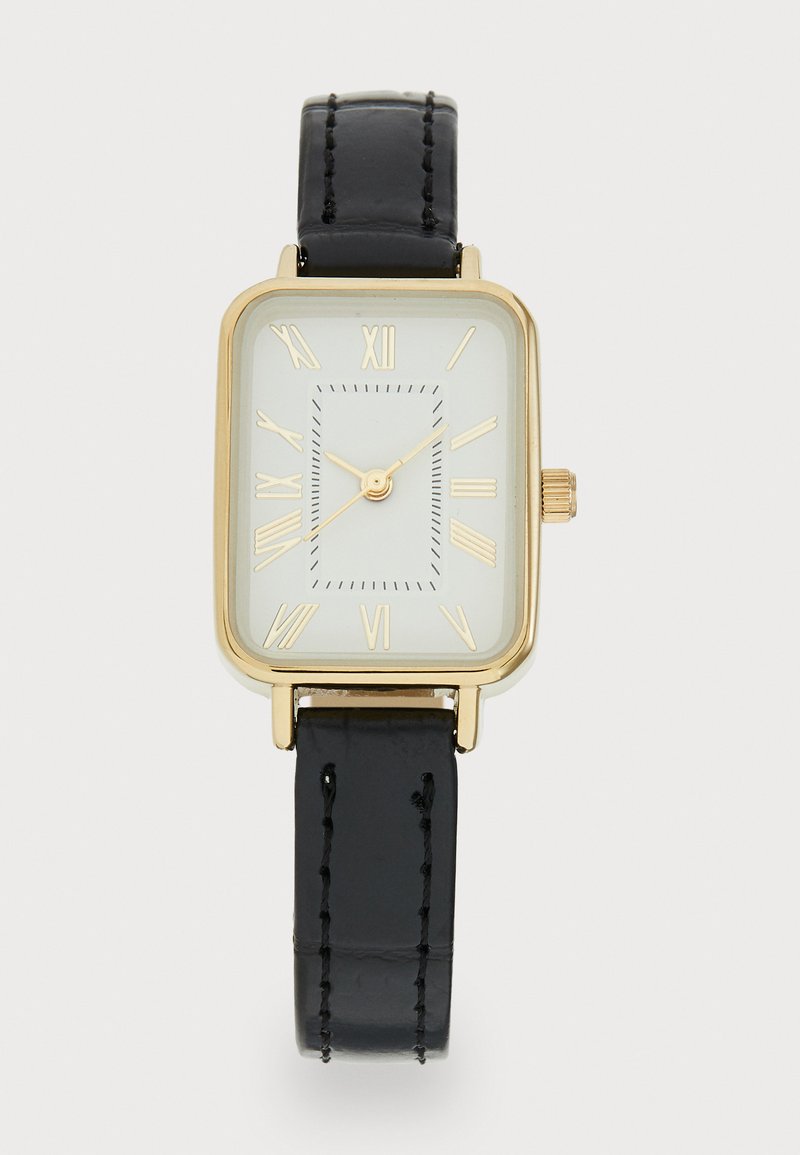 Reloj rectangular dorado con esfera blanca, marcas en números romanos y una correa de cuero negro con detalles de costura.