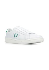Zapatilla blanca de cuero con detalles perforados, talón verde y logo bordado. Presenta cordones planos y suela de goma texturizada.