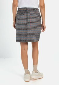 Karierter Bleistiftrock aus mehrfarbigem Stoff mit taillierter Silhouette, ausgestattet mit einem flachen Bund und zwei Gesäßtaschen.