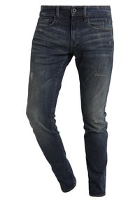 Mörkblå denimjeans med slim fit, med slitna detaljer och subtil blekning, klassisk femfickdesign och dragkedjestängning.
