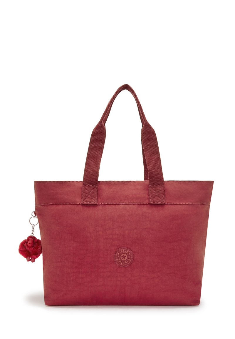 Bolso tote rojo hecho de material texturizado con dos asas, que presenta un logo redondo y un charm de pom-pom adjunto.
