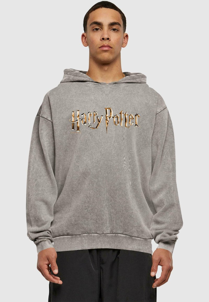 Grå oversize hoodie lavet af blødt stof, med et stort guld "Harry Potter" logo på forsiden, samt en front kangaroo lomme.