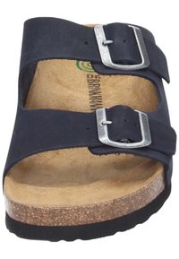 Black suede slide sandal with two adjustable metal buckles, cork midsole, and a textured rubber outsole. Minimal design and open-toe style.
