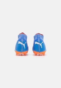 Blauwe sportcleats met oranje zolen, met een gestructureerde bovenkant, hoog enkelontwerp en witte logo-accenten aan beide zijkanten.
