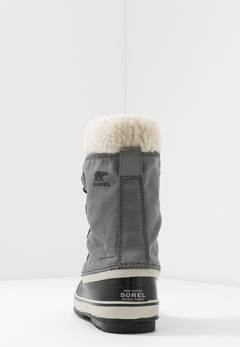 Graue wasserdichte Winterstiefel mit strukturiertem Obermaterial und Kunstfellkragen. Ausgestattet mit einer schwarzen Gummisohle und Sorel-Branding an der Seite.