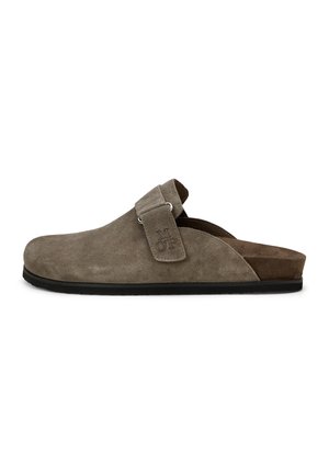 Brauner Wildleder-Clog zum Hineinschlüpfen mit verstellbarem Riemen und schwarzer Sohle, Seitenansicht vor weißem Hintergrund.