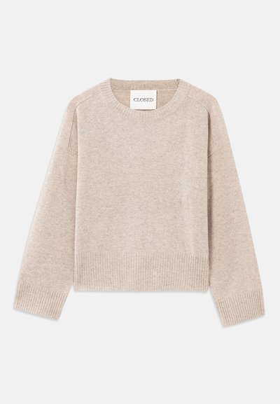 Beige strikket genser med rund hals og ribbestrikkede mansjetter. Har en avslappet passform og subtil tekstur, merket "CLOSED" på lappen.